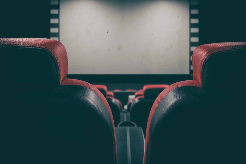 An image of a cinema screen in front of Cinema seating. This image was chosen to depict the movie industry for an article on Samuel Wkwume, the Hollywood movie producer.